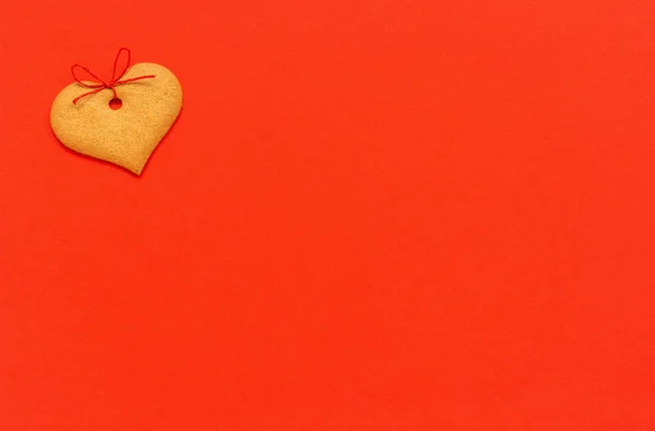 Імбирне печиво у формі серця, прикрашене бантом на червоному тлі. Вид зверху Скопіювати простір Картка Валентина — стокове фото