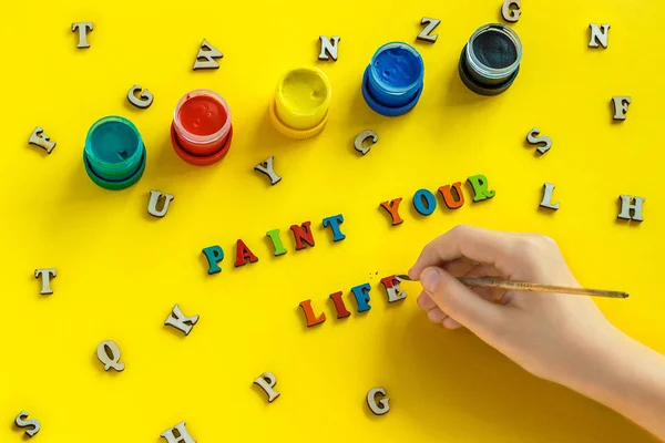 Lettrage Peignez votre vie à partir de lettres colorées, à la main avec pinceau, gouache, lettres en bois éparpillées sur fond jaune, carte de vœux. Concept - Peindre votre vie — Photo