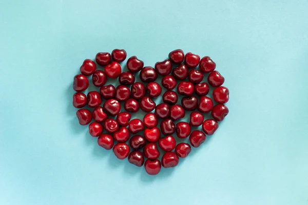 Cherry alakú szív a kék háttér — Stock Fotó