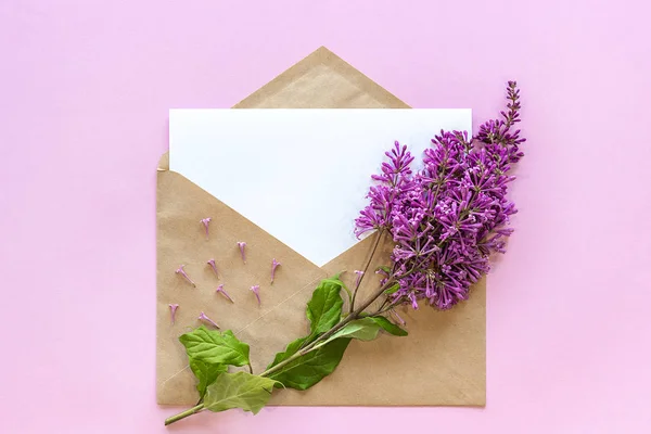 Branch of lilac on craft envelope with empty card — Stock Photo, Image
