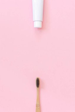 Doğal çevre dostu bambu fırça siyah kıllar ve diş macunu tüp. Kağıt pembe arka planda yıkama için ayarlayın. Metin veya tasarım için boşluk Kopyala üst görünüm düz yatıyordu