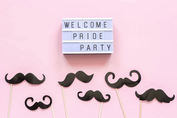 Lightbox text Welcome pride party and paper mustache props on pink background. Concept Homosexuality gay love National Day Against Homophobia or International Gay Day Top view Card invitation