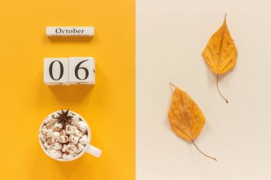 Sonbahar kompozisyon. Ahşap Takvim 6 Ekim, şekerleme ve sarı sonbahar sarı bej arka planda yaprakları ile kakao fincan. Üst görünüm düz Lay mockup konsept Merhaba Eylül