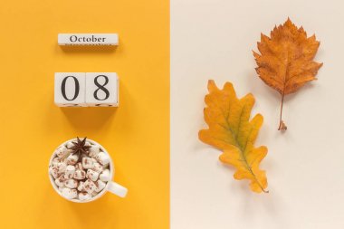Sonbahar kompozisyon. Ahşap takvim 8 Ekim, şekerlemeler ve sarı sonbahar sarı bej arka planda yaprakları ile kakao fincan. Üst görünüm düz Lay mockup konsept Merhaba Eylül