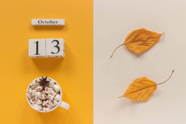 Sonbahar kompozisyon. Ahşap Takvim 13 Ekim, şekerlemeler ve sarı sonbahar sarı bej arka planda yaprakları ile kakao fincan. Üst görünüm düz Lay mockup konsept Merhaba Eylül