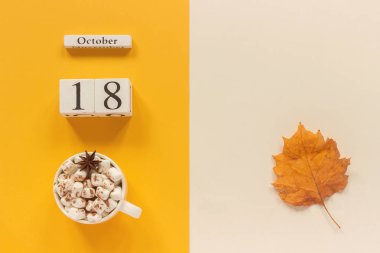 Sonbahar kompozisyon. Ahşap takvim 18 Ekim, sarı bej arka planda Marshmallow ve sarı sonbahar yaprakları ile kakao fincan. Üst görünüm düz Lay mockup konsept Merhaba Eylül