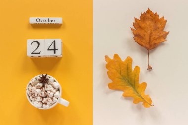 Sonbahar kompozisyonu. Ahşap takvim 24 Ekim, sarı bej arka plan üzerinde marshmallow si lik kakao ve sarı sonbahar yaprakları. Üstten düz yatıyordu Mockup Concept Merhaba Eylül