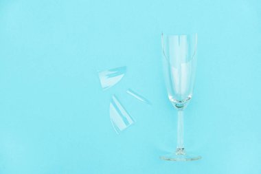 Kopya alanı ile mavi arka plan üzerinde kıymık ile kırık şampanya cam. Alkolizm, sarhoşluk ve alkol reddi karşı Kavram mücadele. Yaratıcı Üst görünüm Düz yatıyordu