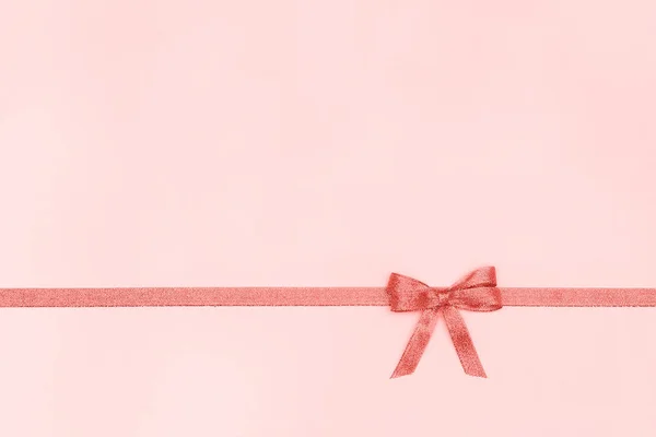 Cinta decorativa brillante con lazo sobre fondo rosa pastel con espacio de copia para texto, coral tonificado Vista superior, Plantilla —  Fotos de Stock