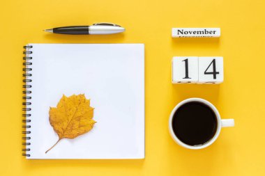 takvim 14 Kasım kahve fincanı, sarı arka plan üzerinde kalem ve sarı yaprak ile not defteri