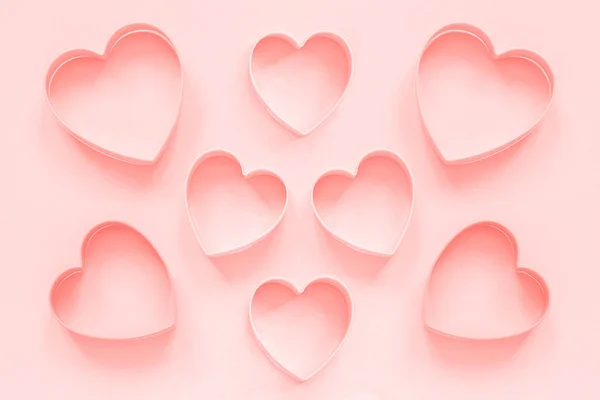 Galletas de corte rosa en forma de corazón sobre fondo rosa pastel, color colar tonificado. Patrón romántico de amor, plantilla —  Fotos de Stock