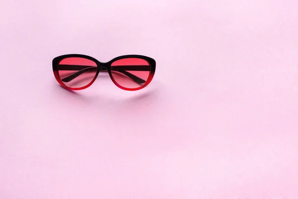 Sluneční brýle na růžových pastelových tapetu — Stock fotografie
