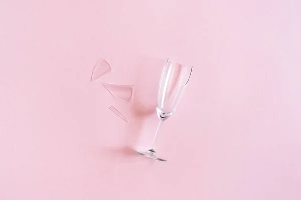 Розбита шампанська флейта з осколками на рожевому тлі з копіювальним простором. Концепція боротьби з алкоголізмом, пияцтвом і відмовою від алкоголю. Креативний вид зверху Плоский прокладка — стокове фото