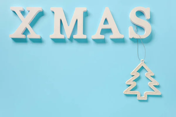 Texto de Navidad de letras blancas y navidad juguete árbol de decoración sobre fondo azul, espacio de copia. Concepto Feliz Navidad. Estilo mínimo Vista superior Plantilla plana para tu diseño, tarjeta, invitación — Foto de Stock