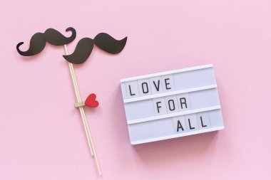 Tüm ışık kutusu metin, pembe arka planda birkaç kağıt bıyık sahne için aşk. Konsept LGBT, Homocinsellik gay aşk ulusal gün karşı Homophobia veya uluslararası gay gün üst görünüm tebrik kartı