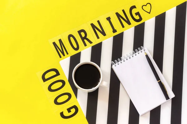 Text Good morning, coffee, notebook for text on stylish black and white napkin on yellow background. Concept good morning — Stock Photo, Image