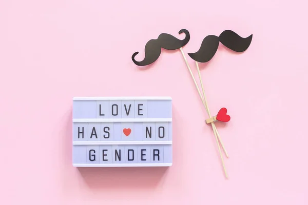 Lightbox text Love has no gender and couple paper mustache props on pink background. Concept Homosexuality gay love National Day Against Homophobia or International Gay Day Top view Greeting card