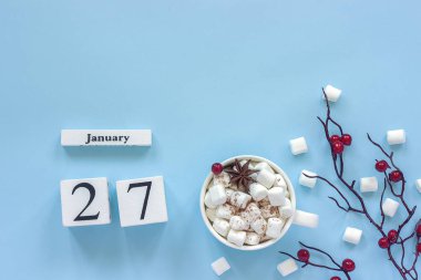 27 Ocak ile beyaz ahşap takvim küpleri. Kakao Fincan, marshmallow ve mavi arka plan üzerinde kırmızı çilek ile dekoratif şube