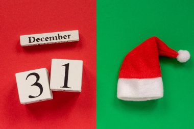 Ahşap takvim 31 Aralık ve Santa veya Baba Frost şapka kırmızı ve yeşil arka plan