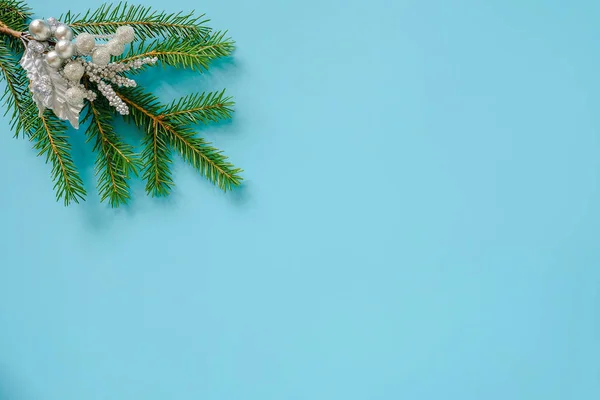 青い背景に緑のモミの枝にシルバーカラーのクリスマスの装飾 — ストック写真