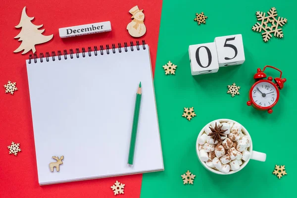 木製のカレンダー12月5日 マシュマロとココアのカップ 赤と緑の背景に目覚まし時計と空のオープンメモ帳 — ストック写真