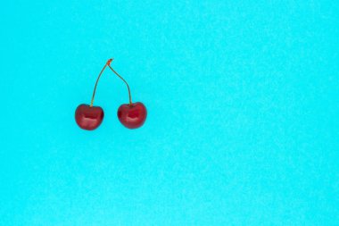 mavi arka plan üzerinde iki olgun kırmızı kiraz, kopya alanı 