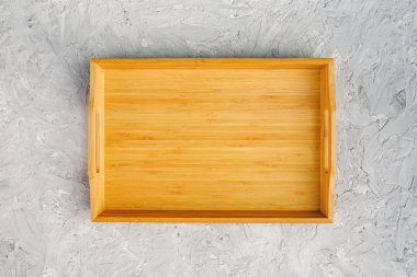 Gri taş masa üzerinde bir boş ahşap tepsi. Üstte Görüntüle Yukarı