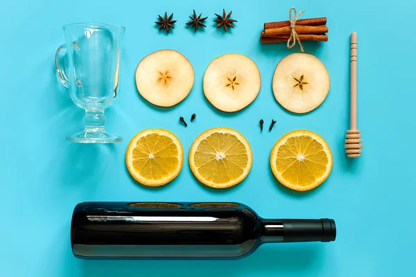 温められたワインの食材、青い背景に静物。ワイン、シナモンスティック、オレンジ、リンゴ、アニス、マグカップのボトル。コンセプト料理レシピ クリエイティブトップビュー フラットレイ — ストック写真