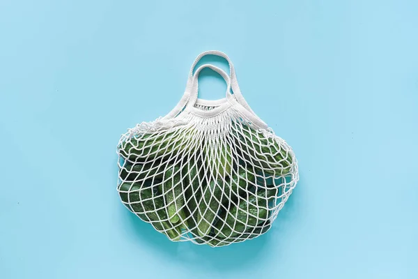 Φρέσκα πράσινα αγγούρια λαχανικά σε επαναχρησιμοποιήσιμες αγορές Eco-Frendly πλέγμα τσάντα σε μπλε φόντο. Η ιδέα δεν είναι πλαστική και μηδενική σπατάλη. Αντιγραφή χώρου επάνω όψη επίπεδη θέση — Φωτογραφία Αρχείου