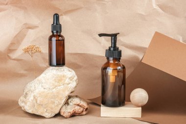 Kahverengi cam kozmetik ürünleri taşın üzerinde ve tahta geometrik şekiller bej el işi kağıt arka planda. Doğal Organik Spa Kozmetik Güzellik Konsepti Ön Görünüm Model.