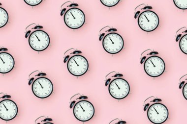 Pembe arka planda siyah alarm saati olan bir model. Metnin ve tasarımın için en küçük biçim Üst Görünüm Şablonu.