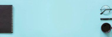 Ofis ya da ev işi. Siyah renkli not defteri, bir fincan kahve, gözlük, mavi arka planda kalem. Modaya uygun iş yeri kavramını, okula geri dön Düz görünüm Üst görünüm Kopyalama Afişi.