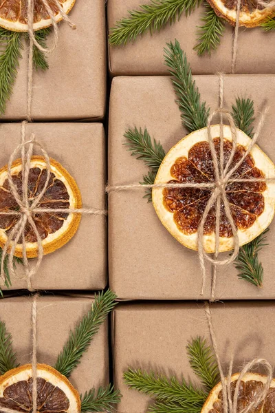 乾燥オレンジ トウヒの枝やツインのクローズアップとクラフト紙の箱からクリスマスや新年のパターン コンセプトゼロ廃棄物 環境に優しいメリークリスマス トップビューフラットレイ — ストック写真