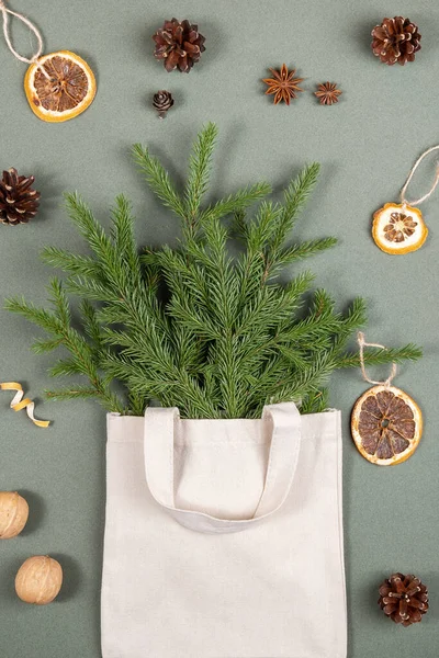 在织物生态袋中的冷杉分枝和绿色背景的环保自然装饰 概念圣诞零浪费 顶视图平铺 — 图库照片