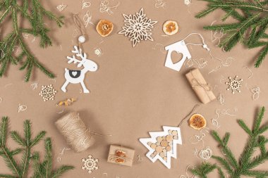 XMAS veya Yeni Yıl kompozisyonu. Çerçeve, kutular, sicim, ahşap süsleme, kurutulmuş portakallar ve bej kaplamalı ladin dallarından yapılmış. Kavram Sıfır israfı Mutlu Noeller kopyalama alanı.