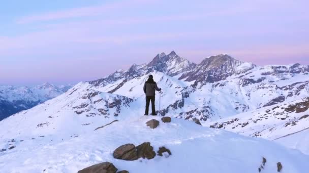 男子举手与登山棒 而站在山顶在日落 — 图库视频影像