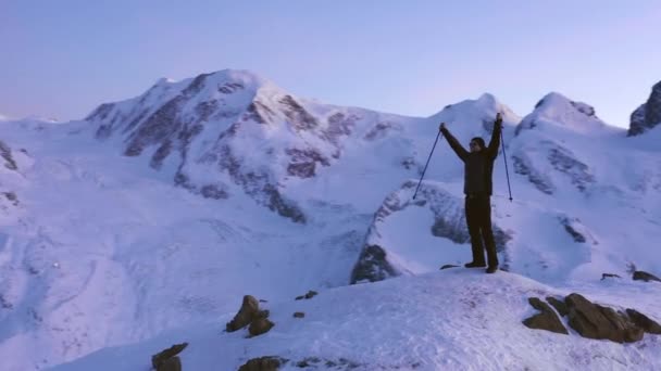 男子举手与登山棒 而站在山顶在日落 — 图库视频影像