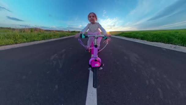 Petite fille mignonne chevauchant le vélo dehors regardant l'harmonie et le bonheur de coucher de soleil d'or Happy Childhood 360 Vr Footage First Person 8k Slow Motion — Video