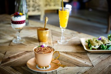 Cappuccino kahve fincanı ahşap masada. 