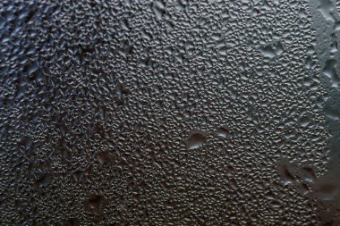 Koyu cama su damlıyor.