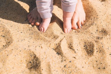 Üst ve alt yalınayak yürümek. Anne ve yaz plaj kum üzerinde ayakları şirin küçük bebek. Aile Tenerife beach Adası, İspanya.