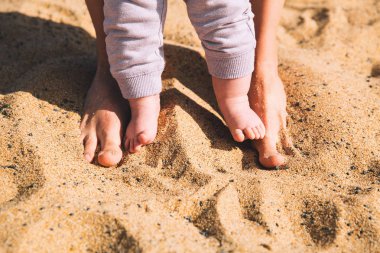 Üst ve alt yalınayak yürümek. Anne ve yaz plaj kum üzerinde ayakları şirin küçük bebek. Aile Tenerife beach Adası, İspanya.