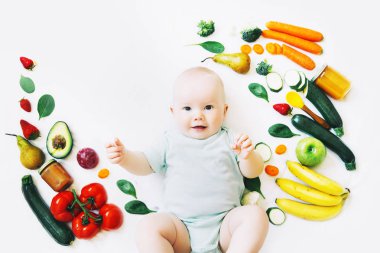 Sağlıklı çocuk beslenme, gıda arka plan, üstten görünüm. Gülümseyen bebek 8 ay yaşlı farklı taze meyve ve sebzeler üzerinde beyaz arka plan ile çevrili. İlk katı besleme bebek