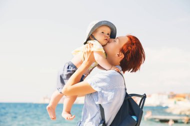 Anne ile kızı olarak coast deniz plaj yakınında eğleniyor. Kadın ve Piran, Slovenya, Avrupa'da tatil, bebek. Üst ve alt, yaz saati açık havada. Mutlu aile rahatlatıcı deniz kenarında.