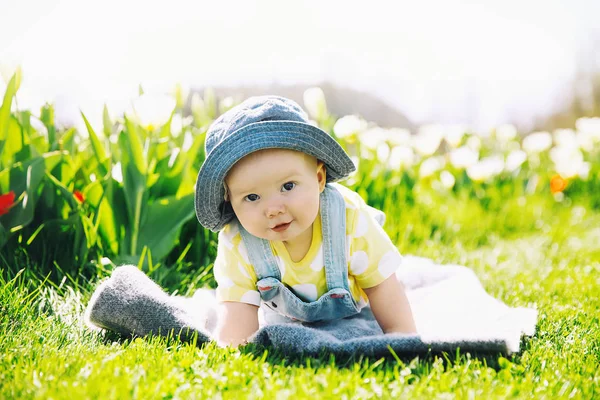 快乐的微笑的女婴躺在郁金香田的绿草毯子上 孩子们在春天公园的户外玩耍 母亲节 复活节的图片 家庭在植物园 斯洛文尼亚 — 图库照片