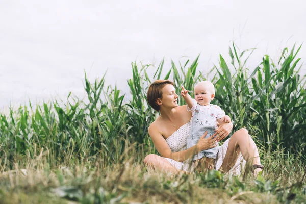 Moeder en baby buitenshuis. Familie op de natuur. — Stockfoto