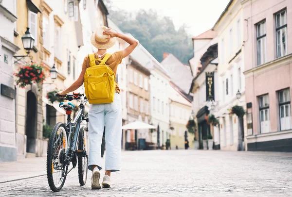 Gadis dengan ransel dan sepeda menjelajahi Ljubljana. Perjalanan Slovenia — Stok Foto