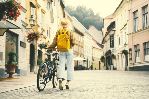 Menina com mochila e bicicleta explora Liubliana. Viagem Eslovénia — Fotografia de Stock