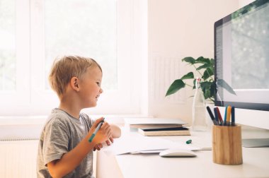 Anaokulu çocuğu bilgisayar teknolojisini erken gelişimde ya da evde eğlence sektöründe kullanıyor. Çocuklar evde eğitim ve uzak online eğitim. Çocuk masa başında çalışıyor ya da yaratıcılık yapıyor. Çocuklar çevrimiçi öğrenme.