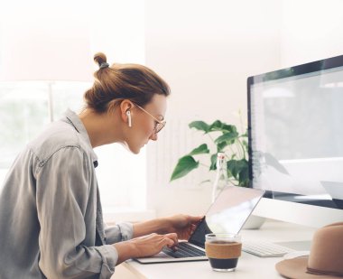 Ofiste dizüstü bilgisayar kullanan bir kadın. Serbest çalışan kadın bir fincan kahve, öğrenci, uzaktan eğitim, çevrimiçi öğrenim ve konsept üzerine yoğunlaştı. Bilgisayarın kapalı olduğu çalışma alanı.